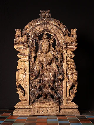 Teakwood panel of the goddess Lakshmi from India, standing figure in ornate arch, front view
