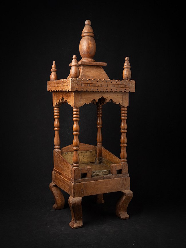 Antique Indian wooden temple, three-quarter view showing roof finials and base