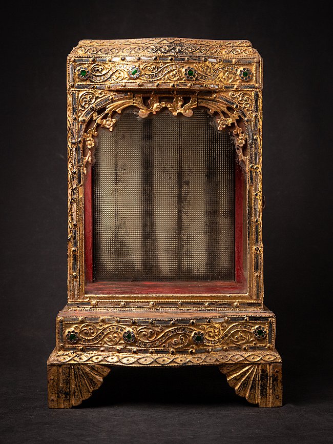 Antique wooden Burmese Buddha temple shrine, front view with gilded frame and red interior