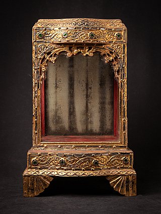 Antique wooden Burmese Buddha temple shrine, front view with gilded frame and red interior