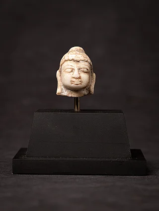 Small antique marble Buddha head on a pedestal