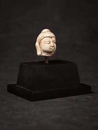 Small antique marble Buddha head on a pedestal