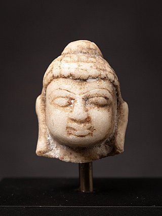 Small antique marble Buddha head on a pedestal