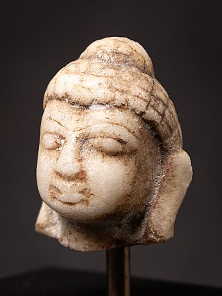 Small antique marble Buddha head on a pedestal