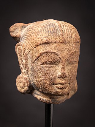 Antique sandstone head of an Apsara statue