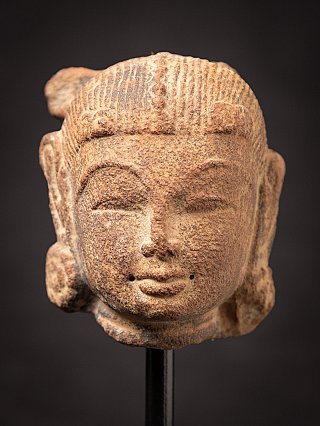 Antique sandstone head of an Apsara statue