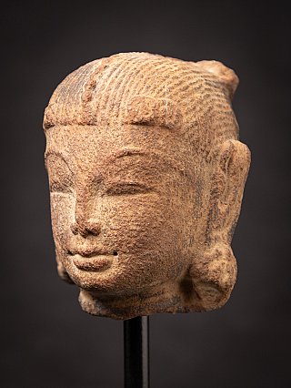 Antique sandstone head of an Apsara statue