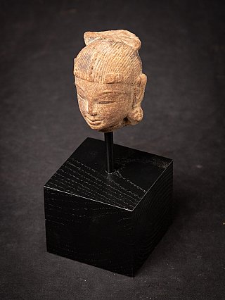 Antique sandstone head of an Apsara statue