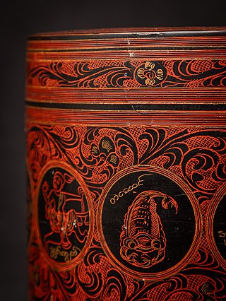 Detail van de zijkant met ronde medaillons en rood gegraveerde bloem- en kruldecoratie