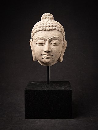 Indian Shakyamuni Buddha head, full front view on a black display base