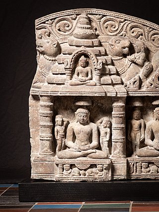 Detail of the left niche with a seated figure, attendants and animal motifs above