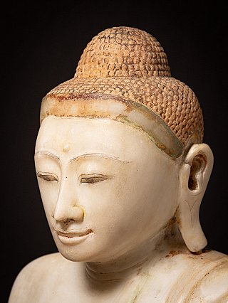 Nahaufnahme des Gesichts der Mandalay-Buddha-Statue aus Marmor mit Haaransatz und Ohr