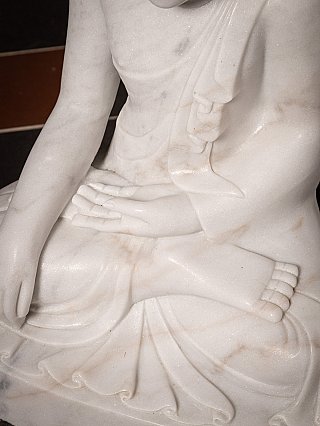 Hands and lap detail of the seated marble Buddha, showing bhumisparsha gesture