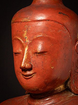 Face detail with traces of gilding along the nose and brows on red lacquer