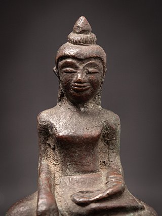 Face detail of the Cambodian bronze Buddha statue, front view