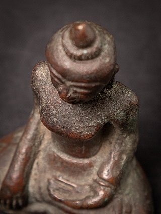 Top-down detail of head and shoulders on the Cambodian bronze Buddha statue