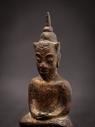 Bronze Buddha statue head and shoulders, three-quarter view close-up
