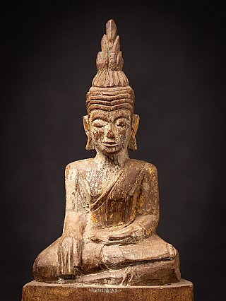 Close-up of the Thai wooden Buddha face and chest with headdress
