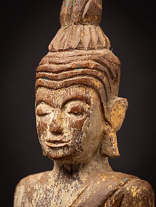 Side face close-up of the Thai wooden Buddha, showing ear and patina