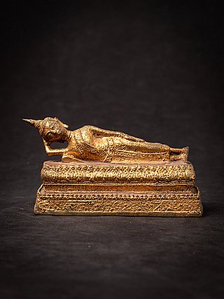 Reclining Thai Buddha statue in bronze on stepped base, left side view