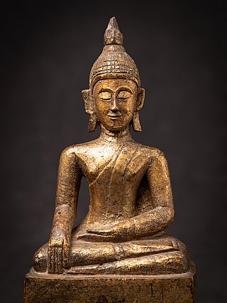 Thai wooden Buddha statue close-up from the front, showing the bhumisparsha gesture