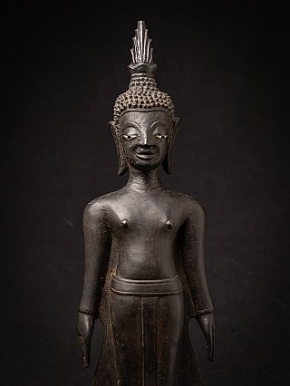 Front close-up of the Laotian bronze Buddha statue showing face, ears and hair curls