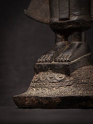 Side close-up of the Laotian bronze Buddha statue base, showing feet and pedestal edge