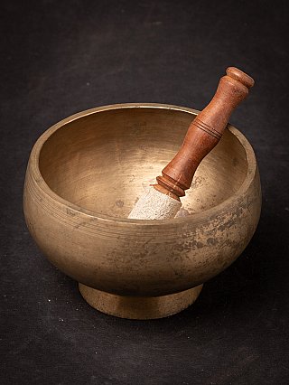Bronze singing bowl from Nepal with striker inside, interior view of the bowl