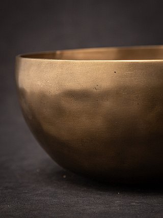 Side detail of the Nepali bronze singing bowl showing the outer surface