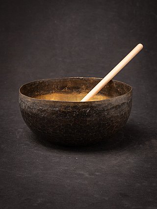 Nepalese bronzen klankschaal met houten klopper, schuin in de kom geplaatst