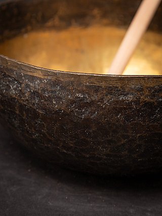 Detail van de rand en buitenwand van de Nepalese bronzen klankschaal met patina