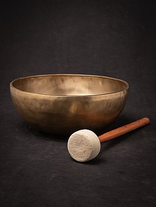 Nepali bronze singing bowl with white-headed mallet placed in front