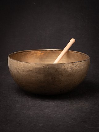 Nepali bronze singing bowl with wooden mallet, three-quarter view into the bowl