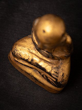 Wooden Burmese monk statue from above, top view focusing on base and head