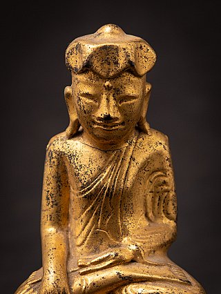 Face close-up of the Burmese wooden Buddha, showing the head shape and aged patina