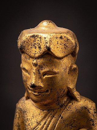 Side-angled face detail of the Burmese wooden Buddha, showing patina and worn finish