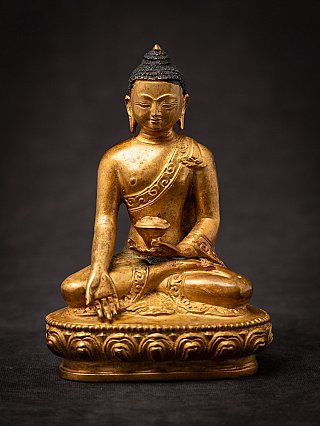 Nepali bronze Buddha statue seated on a lotus base, full front view with lowered hand