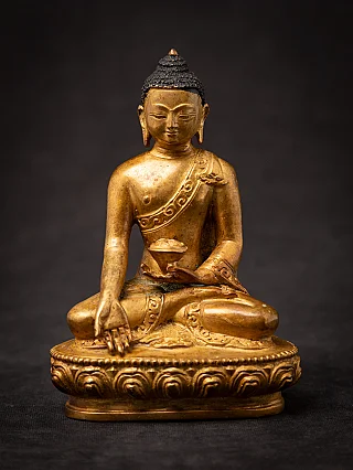 Nepali bronze Buddha statue seated on a lotus base, full front view with lowered hand