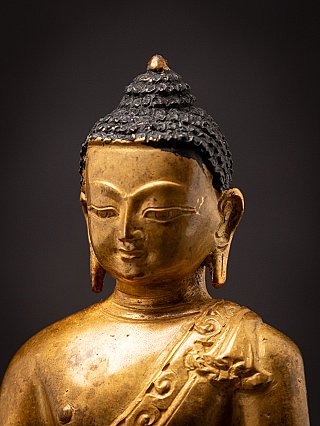 Angled face detail of the Nepali bronze Buddha statue