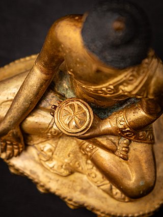 Top-down detail of the bronze Buddha statue showing the bowl in hand and crossed legs