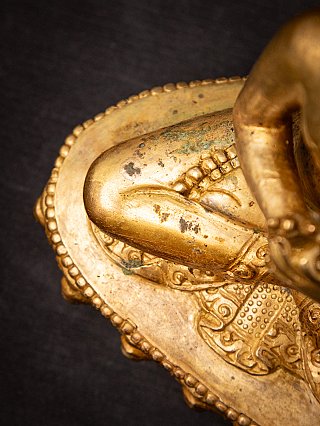 Detail in Draufsicht von Knie und Sockel mit Patina an der nepalesischen Bronze-Statue