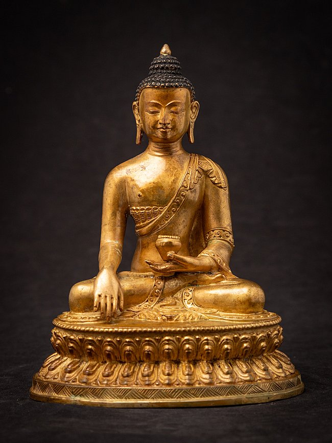 Nepali bronze Buddha statue seated on lotus base, full front view with bhumisparsha mudra