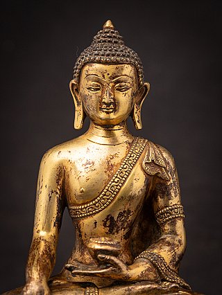 Nahaufnahme der Vorderseite des Gesichts der nepalesischen Bronze-Buddha-Statue mit langen Ohrläppchen