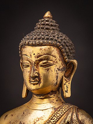 Detail des Buddha-Kopfes in Dreiviertelansicht mit Ohr und Patina