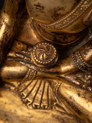 Detail der Hand mit Schälchen im Schoß, mit gefaltetem Gewand über dem Bein
