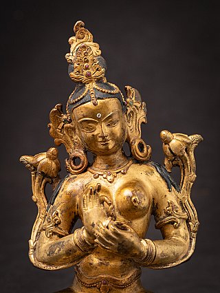 Face and hands detail of the Green Tara bronze statue with necklace visible