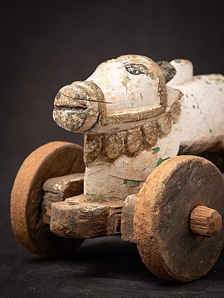 Angled head detail of the wooden Nandi bull with carved neck ornament and wheel