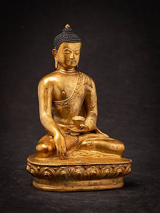 Zittende bronzen Boeddha uit Nepal in bhumisparsha mudra, driekwartaanzicht op lotusvoet