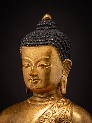 Schuine close-up van het gezicht met haarlokken van het bronzen Boeddhabeeld uit Nepal