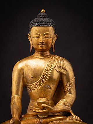Close-up of the face and upper body of the Nepali bronze Buddha statue
